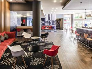 a living room with a couch and tables and chairs at ibis Sao Jose dos Campos Dutra in São José dos Campos