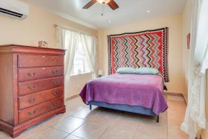a bedroom with a bed and a dresser and a window at Walk Downtown Authentic Adobe Home in Las Cruces! in Las Cruces