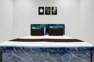 una cama en una habitación con cabecera de mármol en Hotel O Apna Hotel, en Nueva Delhi 23 fotos más