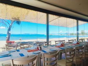 une salle à manger avec une table et une vue sur la plage dans l'établissement Victoria's Suites Corfu, à Lefkimi