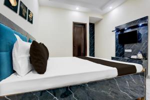 Un dormitorio con una cama y un televisor. en Hotel O Apna Hotel, en Nueva Delhi