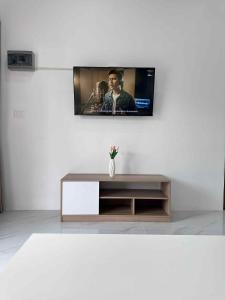 a living room with a tv on a wall at Grandma Samui Garden in Ban Tai