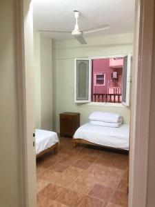 una piccola stanza con due letti e una finestra di Room in santa maria tower hy ell dollar a Marsa Matruh