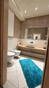 a bathroom with two toilets and a blue rug at Appartamento Elena in San Nicolò di Comelico +6 photos