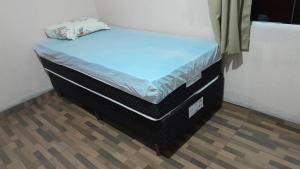 a small bed in a room with two trunks at Quartos em Ametista in Ametista do Sul