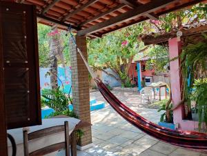 a hammock hanging from a house with a patio at Casa das Gaúchas in Canoa Quebrada