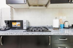 encimera de cocina con fogones y microondas en Modern Flat - Heart of Rabat - Walk Everywhere, en Rabat