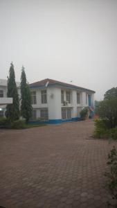 a large white house with a driveway in front of it at Heritage Hotel in Trofwi