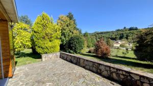 a stone retaining wall next to a yard with trees at Maison du cedre in Bonnac-la-Côte +11 photos