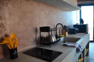 a kitchen counter with a sink and a vase of yellow flowers at Casa Nacui 1 in El Sargento