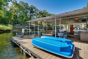 a blue boat sitting on a dock on the water at Lakefront Fun in Sunrise Beach! Pet-Friendly Home! in Sunrise Beach