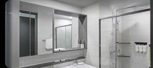 a bathroom with a sink and a shower and a mirror at 오시리아 해운대 in Busan