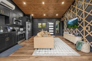 Una sala de estar con un sofá y una cocina. en High-End Smoky Mountain Hideaway With Hot Tub, en Sevierville