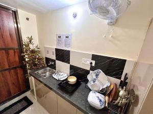 a kitchen with a counter with a fan on the wall at Paradise Stays in Varanasi