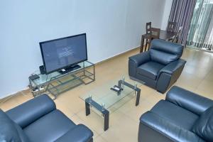 a living room with couches and a flat screen tv at Appartement moderne et lumineux au centre-ville in La Celle-sous-Gouzon