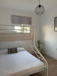 a bedroom with two bunk beds and a pendant light at La Casita de Community SurfHouse El Palmar in El Palmar