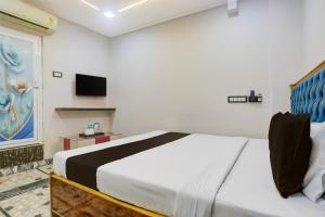 a bedroom with a large bed and a tv at Hotel O The 4th Town in Jamshedpur