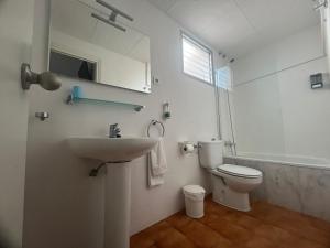 a white bathroom with a toilet and a sink at Nou Rocamar in Sant Carles de la Ràpita