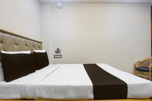 a large bed with a black and white comforter at Hotel O The 4th Town in Jamshedpur