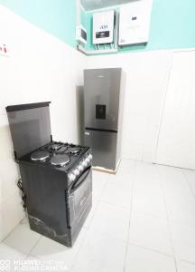 a kitchen with a stove and a refrigerator at Wamz Apartments And Tours B in Livingstone