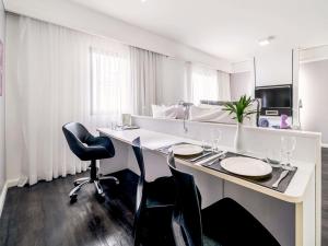 a hotel room with a desk and chairs at Mercure São Paulo Ibirapuera Privilege in São Paulo