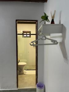 a bathroom with a toilet and a door to a room at Pousada Mandala em frente a Praia da Concha in Itacaré +162 photos