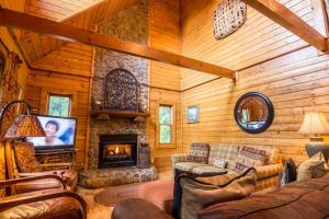 Una sala de estar con chimenea en una cabaña de troncos en 2 Cubs Cabin, en Blowing Rock 22 fotos más