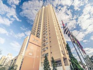a tall building with a flag in front of it at Mercure Sao Paulo Vila Olimpia in Sao Paulo