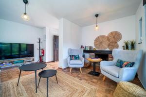 a living room with two chairs and a tv at Villa May en Riegu Vidiago Llanes in Vidiago