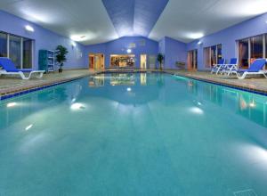 a large swimming pool with blue chairs in a building at Holiday Inn Express Hotel & Suites Pleasant Prairie-Kenosha by IHG in Pleasant Prairie