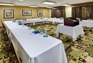 a row of tables in a room with white tables at Holiday Inn Express Hotel & Suites Pleasant Prairie-Kenosha by IHG in Pleasant Prairie +19 photos