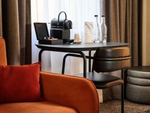 a room with a table with a couch and a chair at Novotel Praha Wenceslas Square in Prague