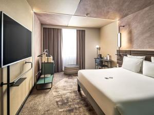 een hotelkamer met een bed en een flatscreen-tv bij Novotel Praha Wenceslas Square in Praag