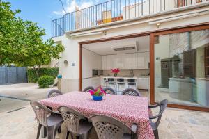 une table avec des chaises et une cuisine dans une maison dans l'établissement Sa Llimonera de Binissalem, à Binissalem