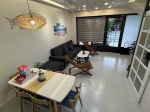 a living room with a couch and a table and chairs at 竺韵旅宿 in Zhushan
