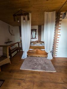a bedroom with a bed with curtains and a rug at Villa Vejini cabin in Mamkoda