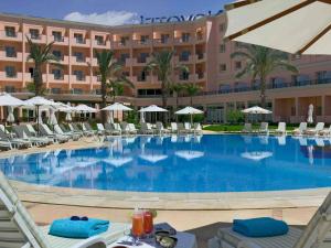 a large swimming pool in front of a hotel at Novotel Cairo 6th Of October in 6th Of October