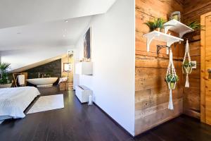 a bedroom with a wooden wall and a bed and a tub at Traumhafte Ferienwohnung in den Schweizer Alpen in Saas-Grund