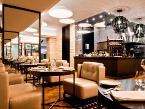 a restaurant with tables and chairs and a bar at Sofitel Warsaw Victoria in Warsaw