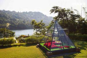 a tent with a bed in it on the grass at Gram's at Shivom, Pawna Lake in Lonavala