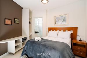 a bedroom with a bed with two white towels on it at Aptos completos em prédio com piscina a 850m da Praia no Centro de Floripa - RIIs in Florianópolis +9 photos