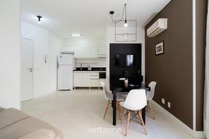 a kitchen and dining room with a table and chairs at Aptos completos em prédio com piscina a 850m da Praia no Centro de Floripa - RIIs in Florianópolis