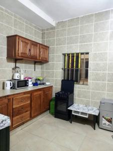 a kitchen with wooden cabinets and a stove at 1 chambre salon climatisé in Cotonou +32 photos