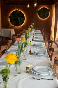a long table with white plates and flowers in vases at Agriturismo i Due Mori in Treia