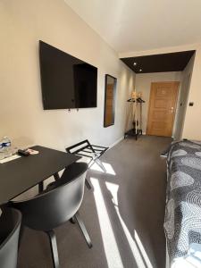 a room with a table and a television on the wall at Rozmaryn Hotel B&B in Rakovník