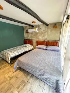 Dos camas en una habitación con suelo de madera. en Apartamento Pardo1945 TIPO INDUSTRIAL, en Mompós