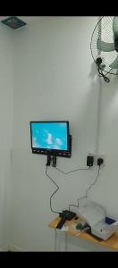a flat screen tv on a wall with a fan at D-Bayu Motel in Papar
