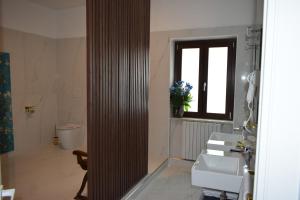 Un baño con dos lavabos y un inodoro y una ventana. en Villa Francesca Luxury Rooms, en San Demetrio Corone 32 fotos más