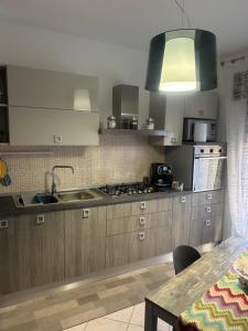 エンナにあるAnchida casa vacanzeのキッチン(木製キャビネット、シンク、コンロ付) +5枚の写真