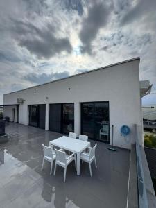 a white table and white chairs on a patio at Sky View Penthouse in Craiova
